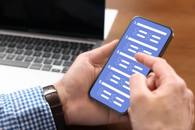 Image of Man passing online test on his mobile phone at table, closeup