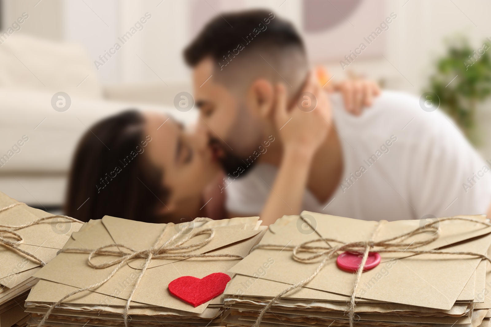 Romantic young couple and love letters, bokeh effect. Woman and man kissing at home Image of Romantic young couple and love letters, bokeh effect. Woman and man kissing at home