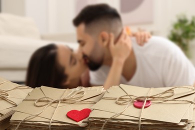 Image of Romantic young couple and love letters, bokeh effect. Woman and man kissing at home