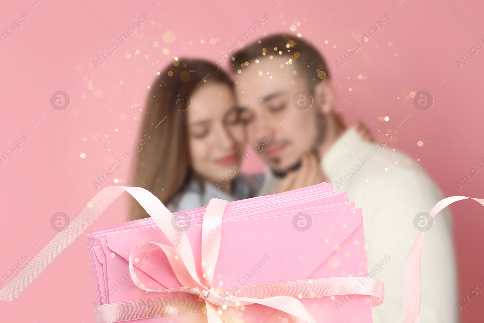 Romantic young couple and love letters against pink background, bokeh effect Image of Romantic young couple and love letters against pink background, bokeh effect