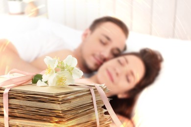 Image of Romantic young couple in bed and stack of love letters
