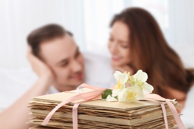 Image of Romantic young couple and stack of love letters
