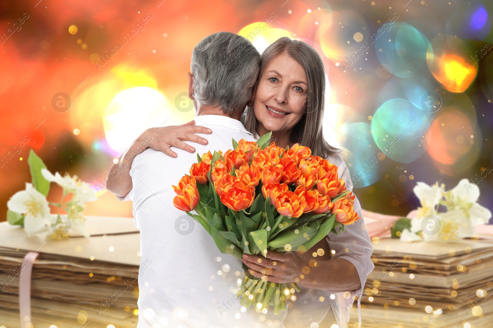 Romantic senior couple and love letters, bokeh effect. Woman with bouquet hugging her beloved man Image of Romantic senior couple and love letters, bokeh effect. Woman with bouquet hugging her beloved man