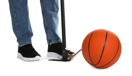 Photo of Man inflating basketball ball with manual air pump on white background, closeup