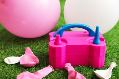 Photo of Balloons and air pump indoors, closeup view