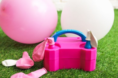 Photo of Balloons and air pump indoors, closeup view
