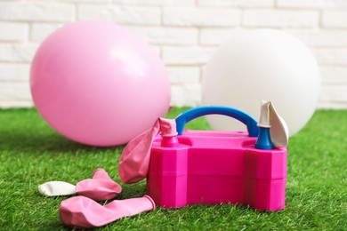 Photo of Balloons and air pump indoors, closeup view
