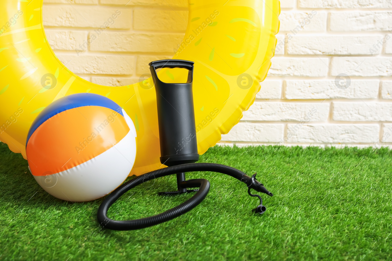 Photo of Ball, inflatable ring and manual air pump indoors, space for text