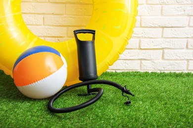 Photo of Ball, inflatable ring and manual air pump indoors, space for text