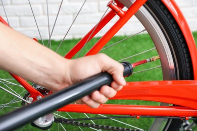 Photo of Man inflating bicycle tire with manual air pump indoors, closeup