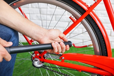 Photo of Man inflating bicycle tire with manual air pump indoors, closeup