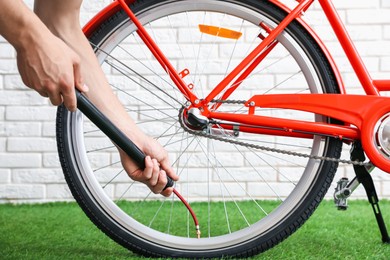 Photo of Man inflating bicycle tire with manual air pump indoors, closeup