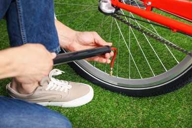 Photo of Man inflating bicycle tire with manual air pump indoors, closeup