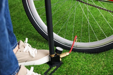 Photo of Man inflating bicycle tire with manual air pump indoors, closeup