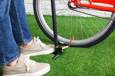 Photo of Man inflating bicycle tire with manual air pump indoors, closeup