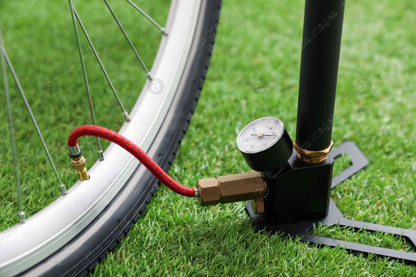 Bicycle and manual air pump on artificial grass, closeup Photo of Bicycle and manual air pump on artificial grass, closeup