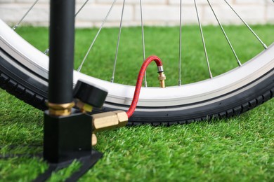 Photo of Bicycle and manual air pump indoors, closeup