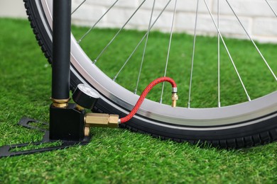 Photo of Bicycle and manual air pump indoors, closeup