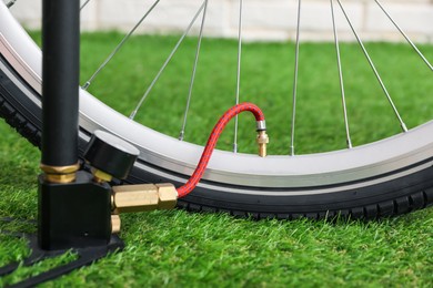 Photo of Bicycle and manual air pump indoors, closeup