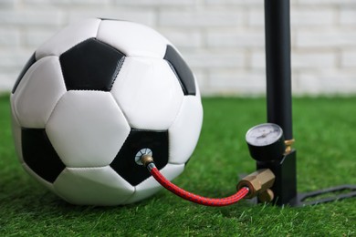 Photo of Soccer ball and manual air pump indoors, closeup