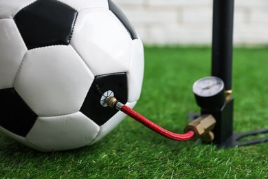 Photo of Soccer ball and manual air pump indoors, closeup