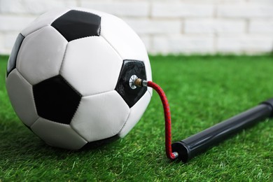 Photo of Soccer ball and manual air pump indoors, closeup