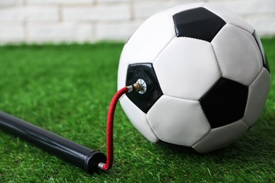 Photo of Soccer ball and manual air pump indoors, closeup