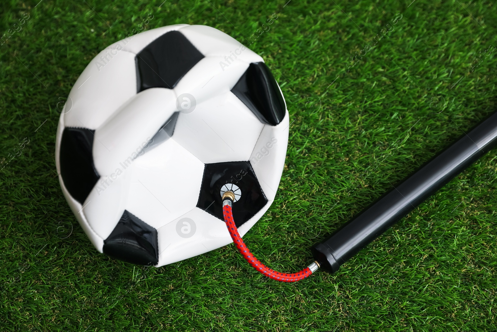 Soccer ball and manual air pump on artificial grass Photo of Soccer ball and manual air pump on artificial grass