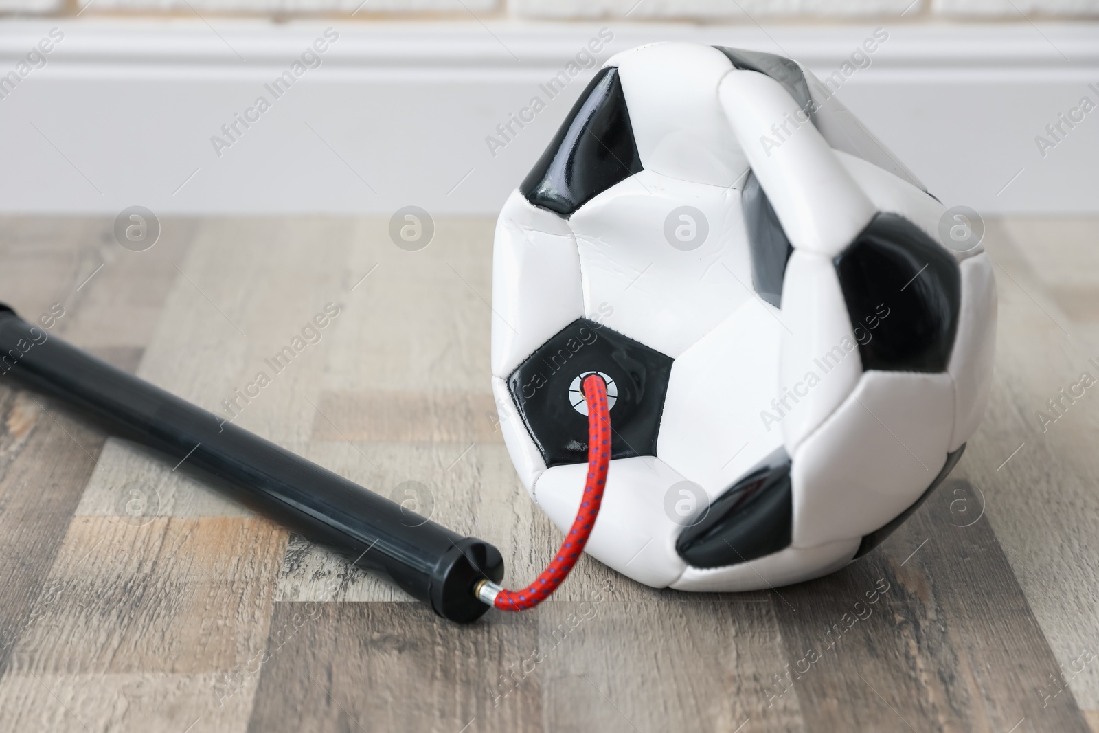 Soccer ball and manual air pump indoors, closeup Photo of Soccer ball and manual air pump indoors, closeup