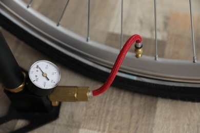 Photo of Bicycle and manual air pump indoors, closeup