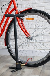 Photo of Bicycle and manual air pump indoors, closeup