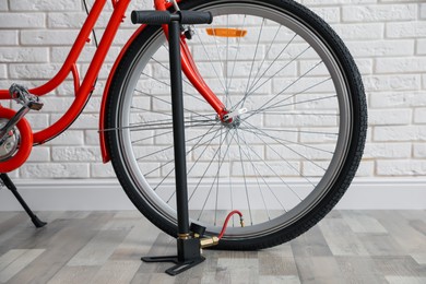 Photo of Bicycle and manual air pump indoors, closeup