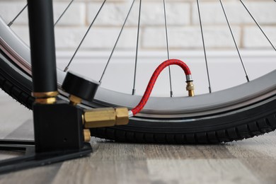 Photo of Bicycle and manual air pump indoors, closeup