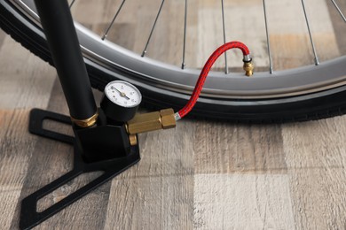 Photo of Bicycle and manual air pump indoors, closeup