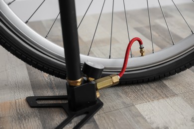 Photo of Bicycle and manual air pump indoors, closeup