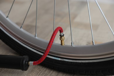 Photo of Bicycle and manual air pump indoors, closeup