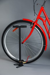 Photo of Bicycle and manual air pump on grey background, closeup