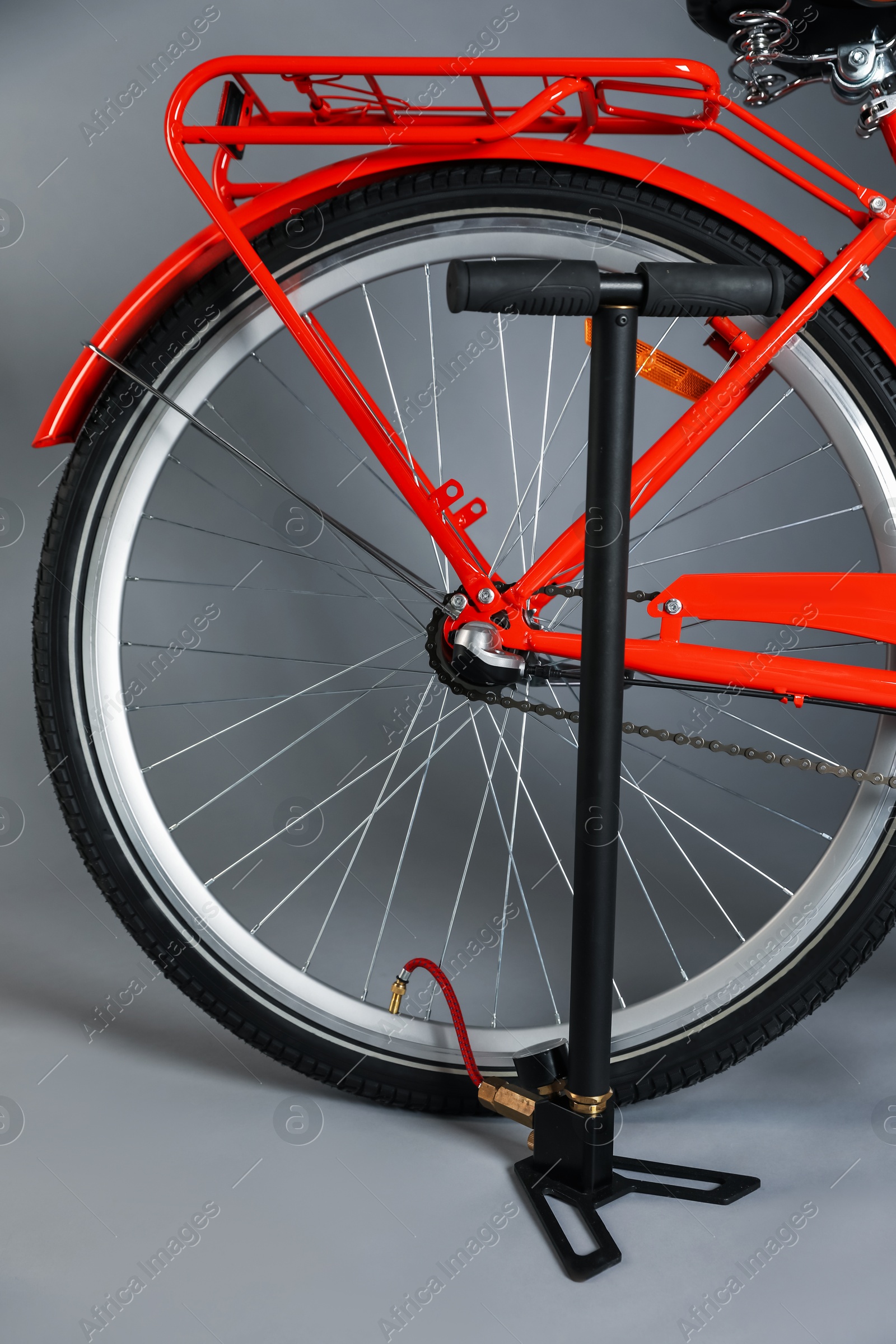 Bicycle and manual air pump on grey background, closeup Photo of Bicycle and manual air pump on grey background, closeup