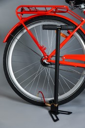 Photo of Bicycle and manual air pump on grey background, closeup