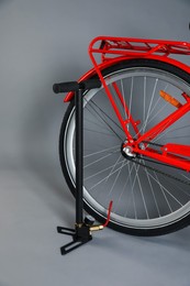 Photo of Bicycle and manual air pump on grey background, closeup