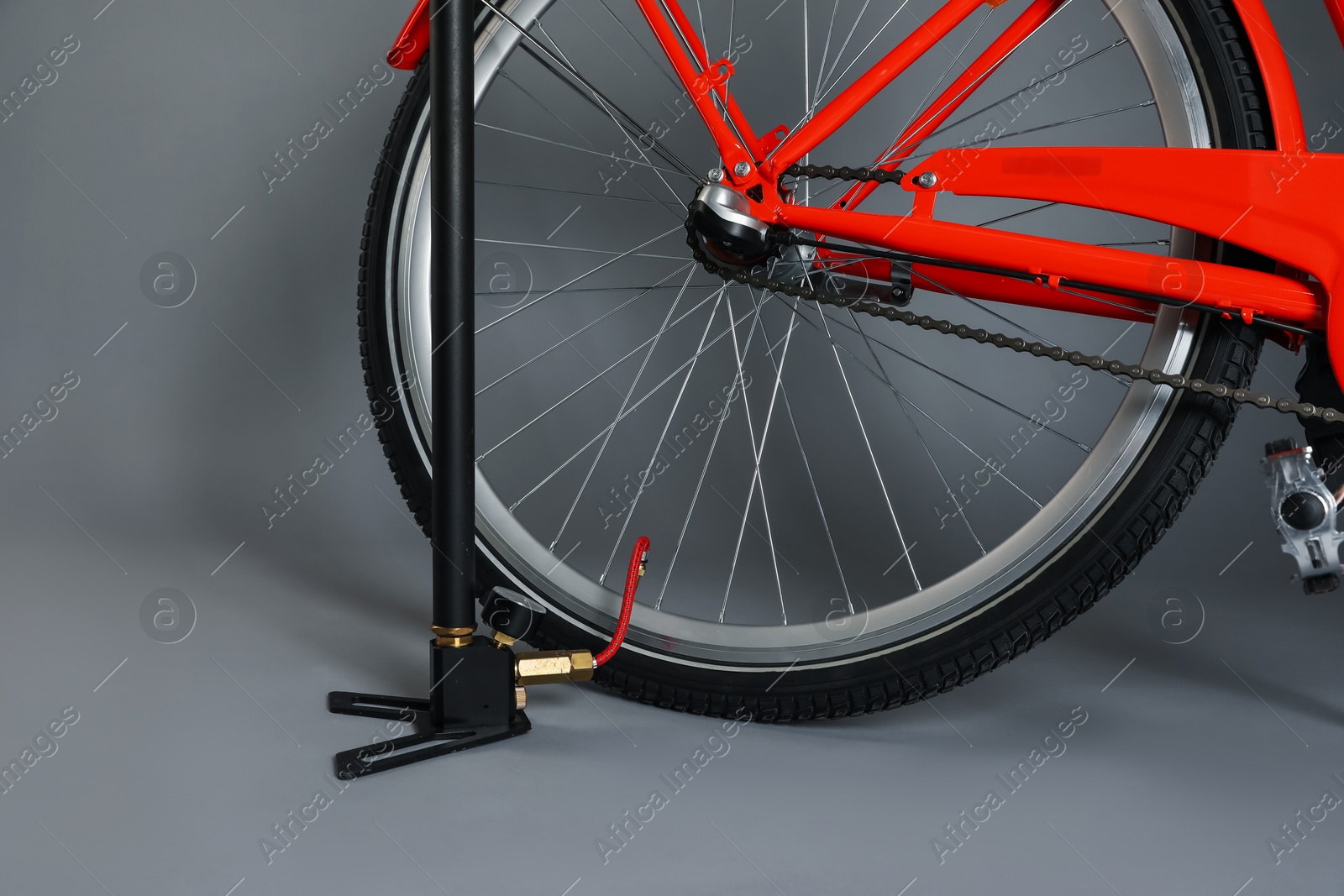 Bicycle and manual air pump on grey background, closeup Photo of Bicycle and manual air pump on grey background, closeup