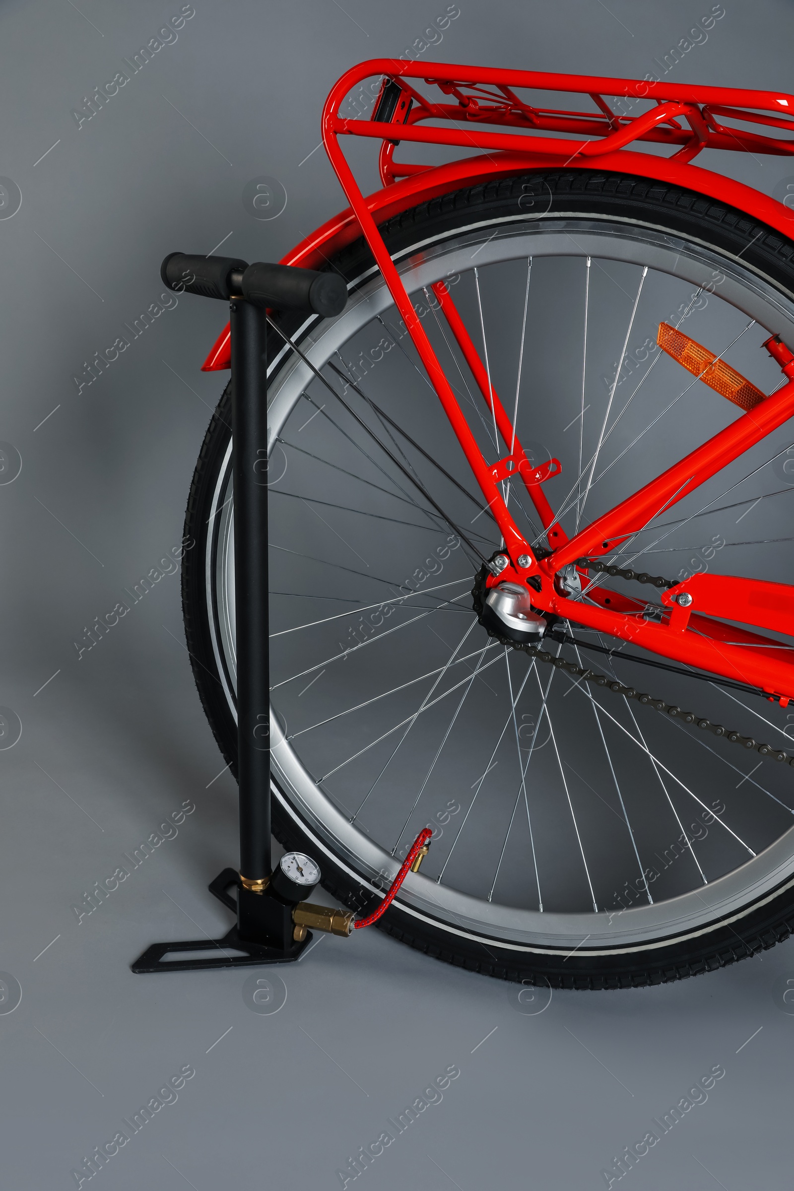 Photo of Bicycle and manual air pump on grey background, closeup