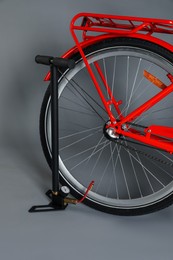 Photo of Bicycle and manual air pump on grey background, closeup
