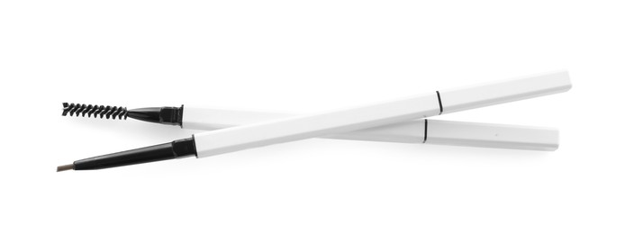 Photo of Two twist up eyebrow pencils isolated on white, top view