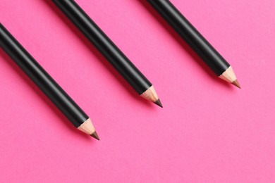 Photo of Different eyebrow pencils on bright pink background, flat lay. Space for text