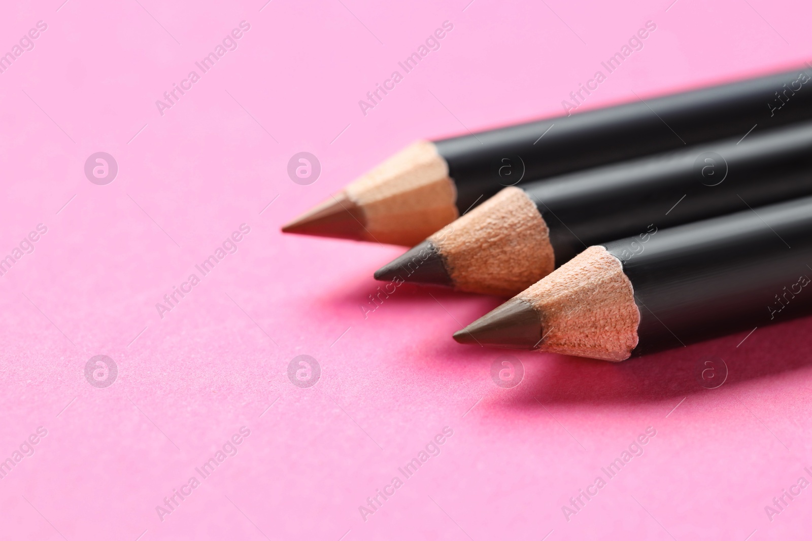 Different eyebrow pencils on bright pink background, closeup. Space for text Photo of Different eyebrow pencils on bright pink background, closeup. Space for text