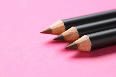 Photo of Different eyebrow pencils on bright pink background, closeup. Space for text