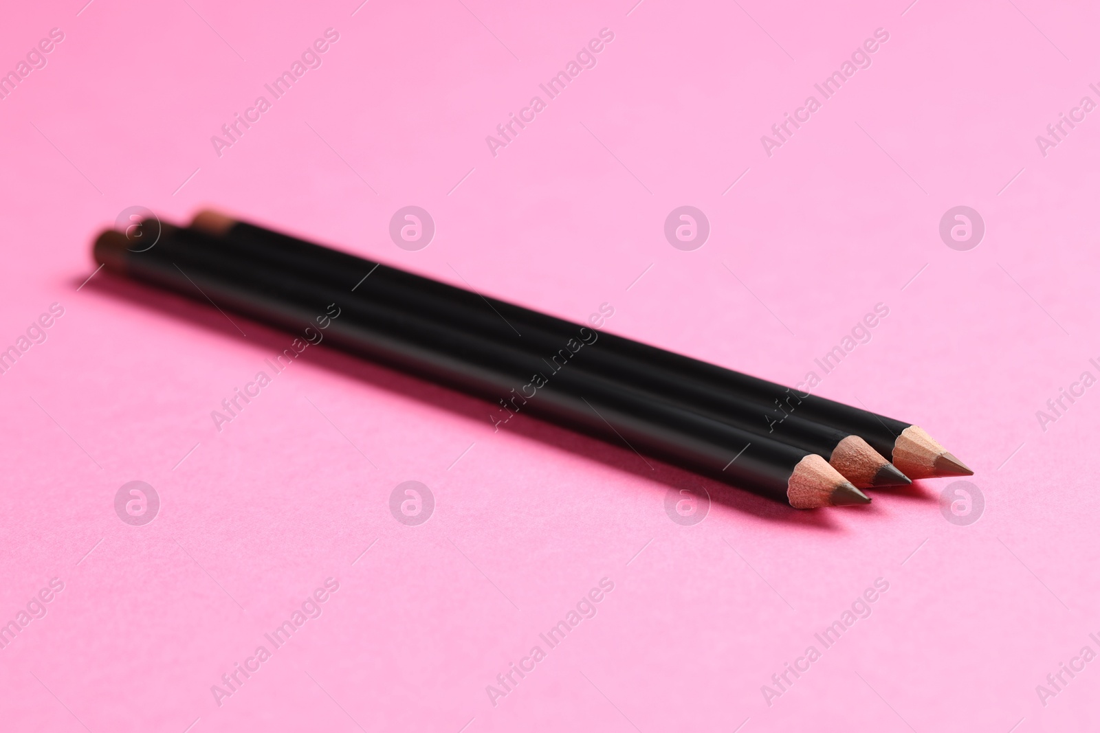 Different eyebrow pencils on bright pink background, closeup Photo of Different eyebrow pencils on bright pink background, closeup