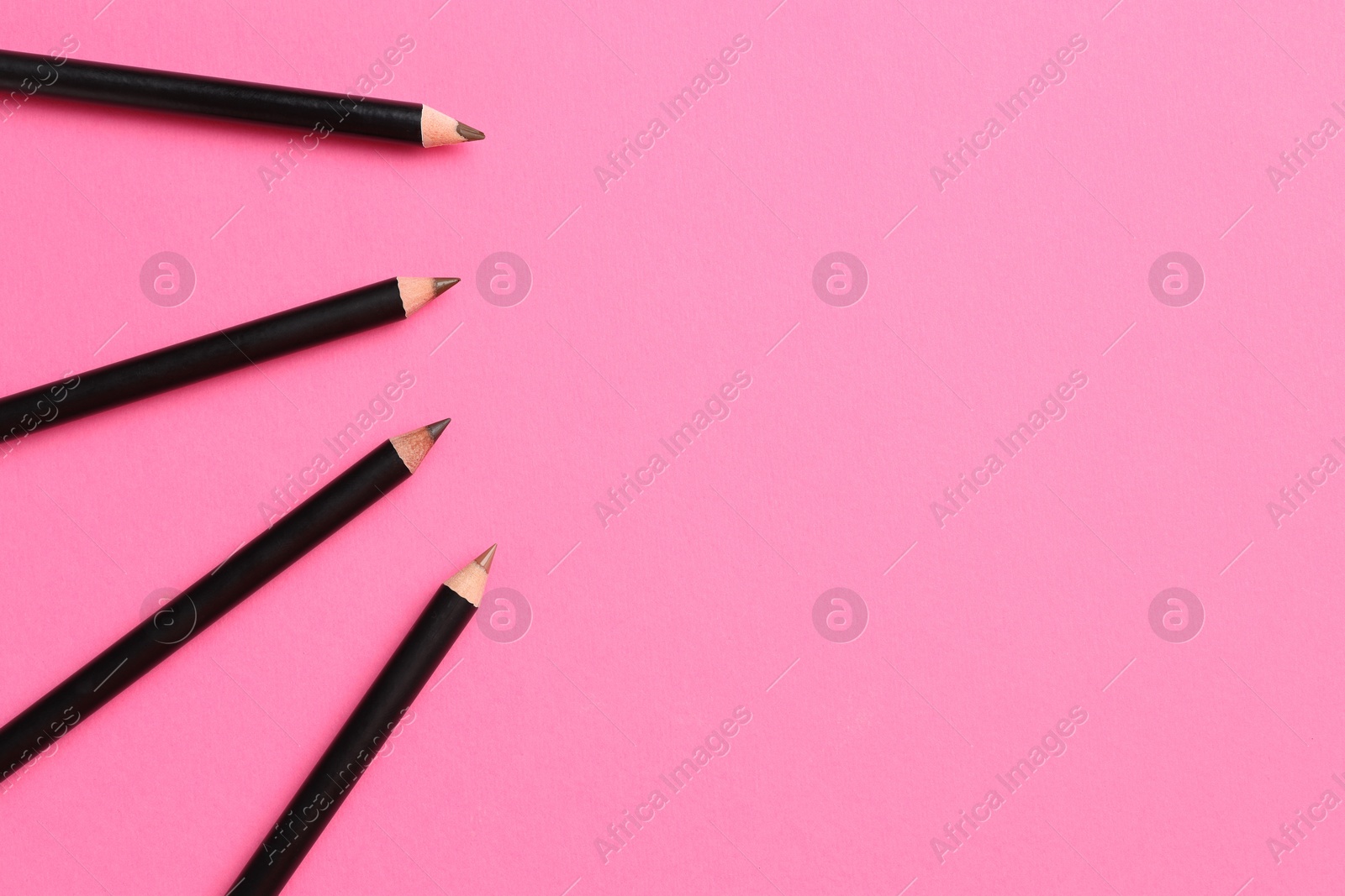 Different eyebrow pencils on bright pink background, flat lay. Space for text Photo of Different eyebrow pencils on bright pink background, flat lay. Space for text