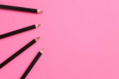 Photo of Different eyebrow pencils on bright pink background, flat lay. Space for text